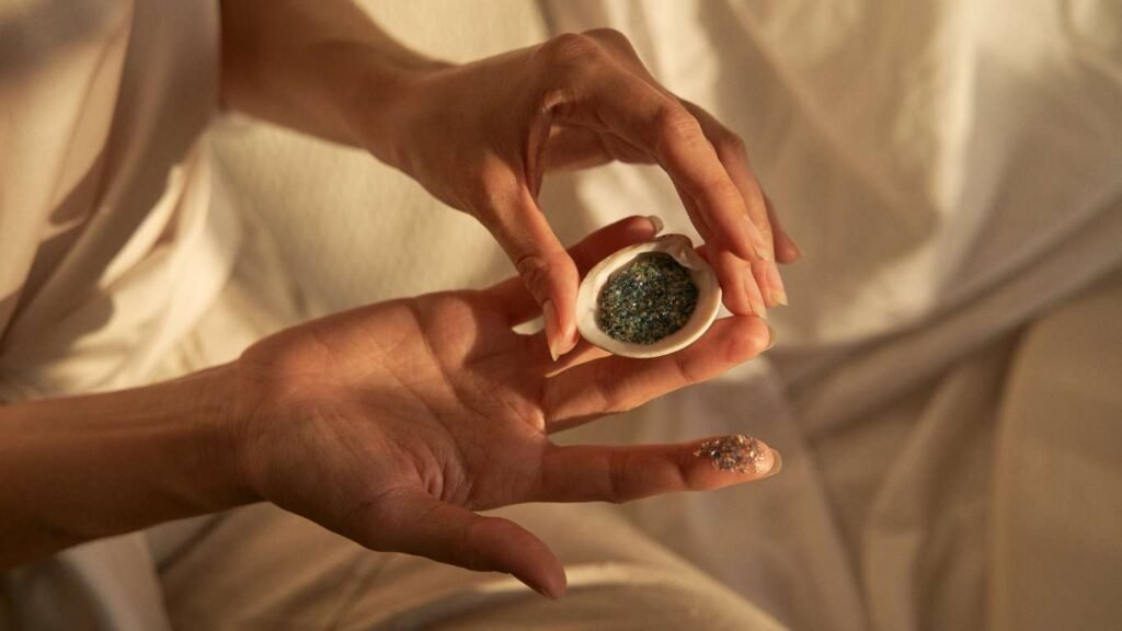 Purpurina de algas en una concha sujeta por las manos