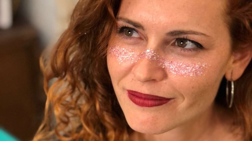 Modelo pelirroja con purpurina para la cara