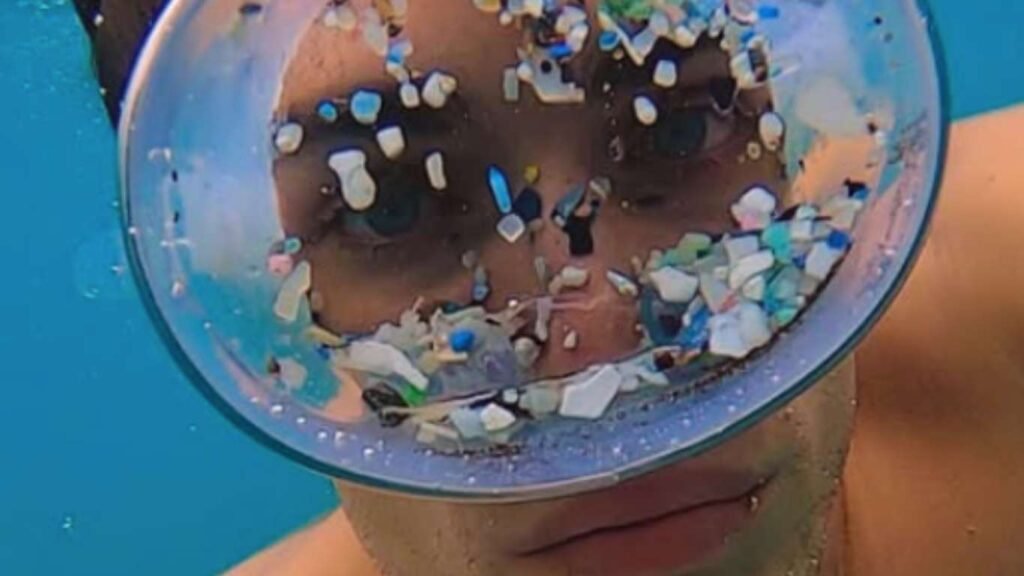 Modelo con gafas de apnea con plástico bajo el mar